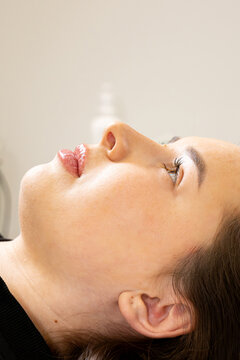 A picture of a very beautiful and attractive young lady showing the process of a lip rejuvenation procedure, in a professionally designed office. This look is very popular on the market, attractive to