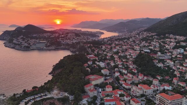 Dubrovnik, Croatia. Aerial 4K panoramic drone view at sunset or sunrise of the peninsula with the old medieval town, harbor and Adriatic cityscape. View of the medieval town, ancient fortress, resort.