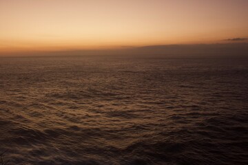 Obraz premium Dramatic Ocean Horizon at Sunset with Warm Golden Sky