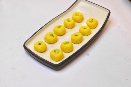 Peda sweet garnished with pista on white plate