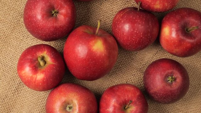 Ripe red apples rotating on burlap background