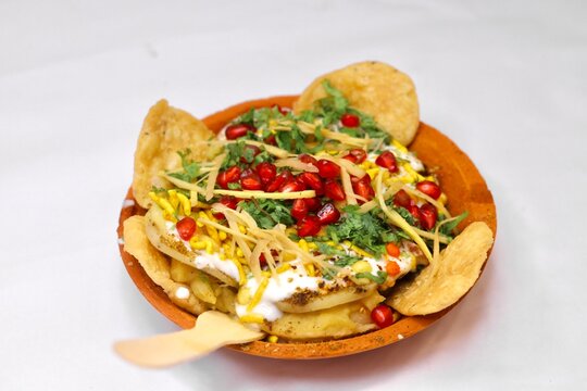 Papdi chaat on white background served in an earthen plate