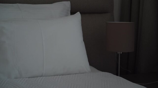 Turning a bedside lamp on and off in a cozy bedroom, evening routine and home comfort concept