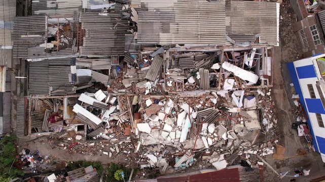 Aerial drone view of severely damaged houses, rubble, and collapsed roofs in the Grisales neighborhood, Quimbaya, Quindio, Colombia, following the August 2026 earthquake