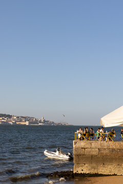 outdoor restaurant on a concrete dock next to ocean in Europe on sunny day