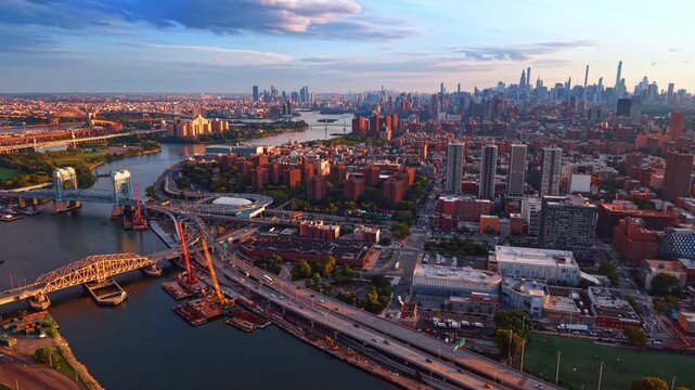 Beautiful scenery of South Bronx skyline in New York City at sunset time. Flyover the Harlem River approaching the Willis Avenue Bridge and the Third Avenue Bridge across the waterscape.