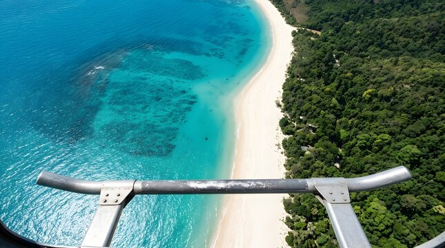 Tropical beach with white sand meets lush green jungle and turquoise ocean from the perspective of a helicopter.