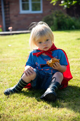 Child superhero enjoying snack outdoors. © Rawpixel.com