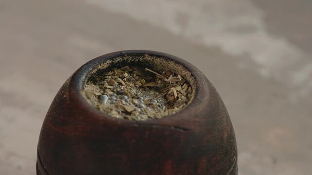 Close up of hot water being poured from a thermos into a traditional yerba mate gourd
