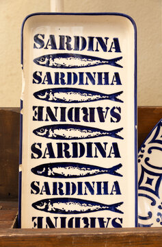 traditional blue and white ceramic handmade plates for sardines for sale at a souvenir shop in portugal