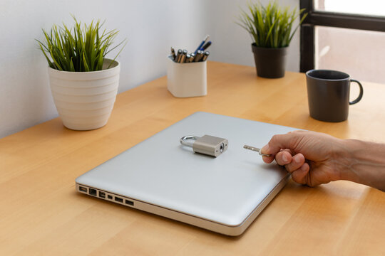 Cybersecurity concept with locked laptop padlock and key