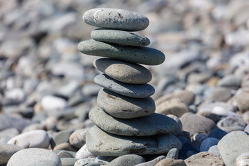 Tall tower of rounded stones rises on pebble beach © schankz