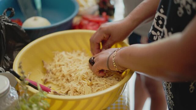 Woman's hands preparing shredded chicken meat for a traditional mexican recipe at home tinga
