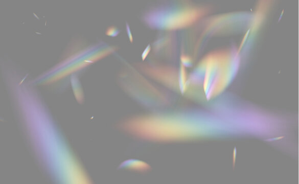 Light refraction creates fragmented rainbow streaks on a black background. The scattered fragments show soft, colorful spectral bands with varied shapes and sizes.