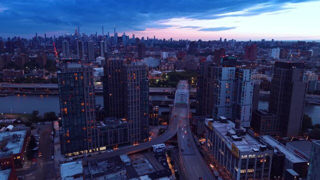 Flight over the Mott Haven neighborhood skyline in the South Bronx, New York City. Lots of cars move to the Third Avenue Bridge across the Harlem River at dusk.