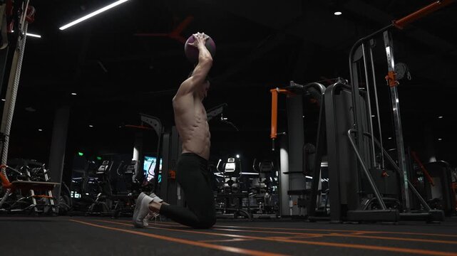 Fitness workout of sportsman with ball in gym. Sportsman do workout in fitness gym. Muscular man throw fitness ball on gym floor. Fit man ball workout in fitness gym. Ball power move
