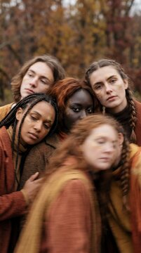 Diverse Group With Golden Face Art Huddles Together In A Quiet Autumn Forest