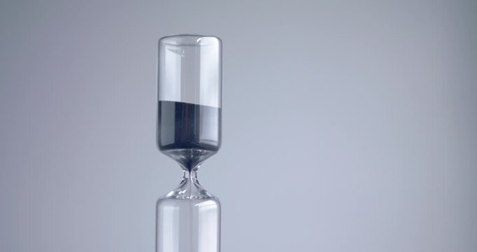 Close up shot of modern design sand clock / hourglass on a grey background.