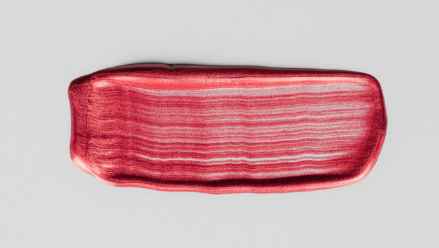Red metallic shimmer paint stroke cosmetic texture