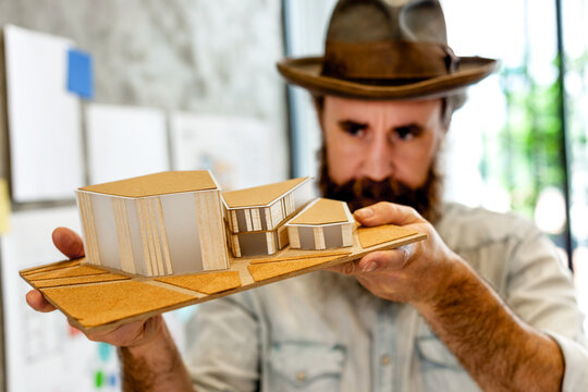 Architect showcasing modern building model.