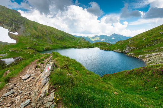 lake in romania mountain landscape. clear source of water. outdoor adventures in summer. cloudy sky over the fagaras ridge