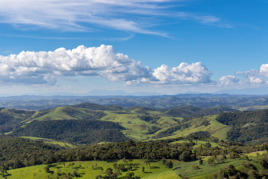Rolling Green Hills Beneath Dramatic Clouds and Blue Sky