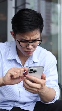 slow motion scene asian businessman with stress emotion on face with during hold smartphone to reading about bad comment on social media application or read news and rumor