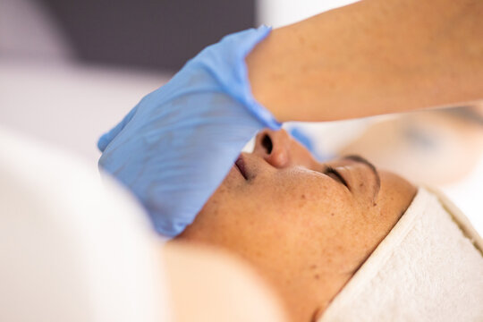 Professional facial cleansing treatment with protective gloves