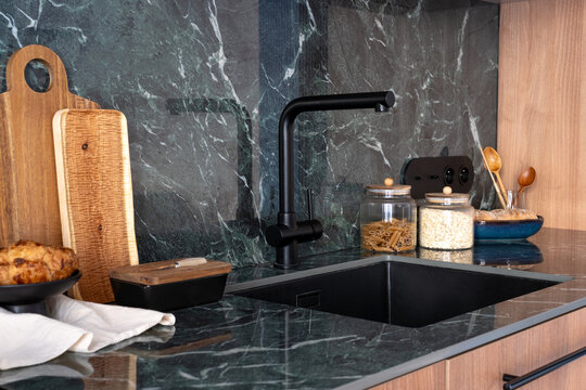 Modern kitchen with green marble countertop and faucet above the sink