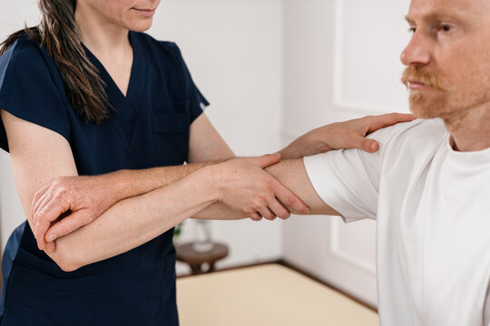 Physiotherapist examines a patient's joint during rehabilitation therapy session