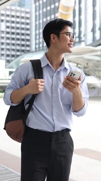 slow motion wmployee mancheck smartphone while standing outside building in the city and looking away with vision for future financial and motivation on business achievement concept