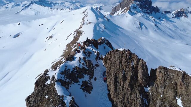 Felsturm mit zwei winzigen Skifahrern am Gipfel &ndash; dramatisches Adventure-Feeling aus der Luft
