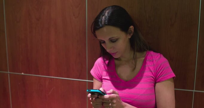 Female smiling while sending text messages 4k

