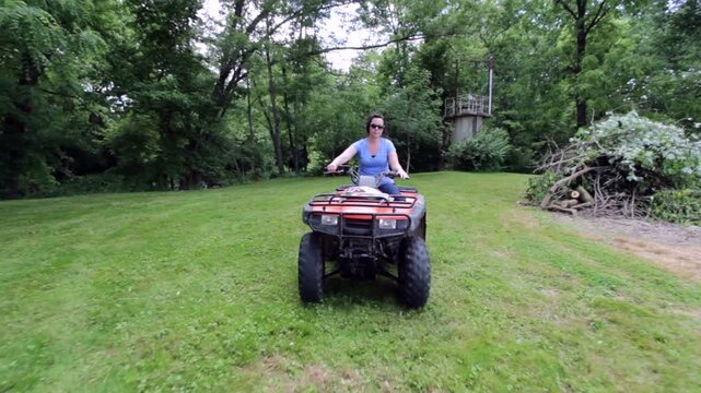 Female riding on four wheeler towards camera