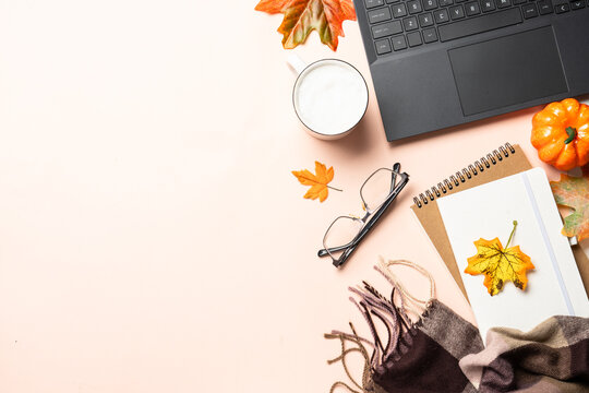 Autumn office desk. Laptop, notebook, coffee cup and yellow leaves.