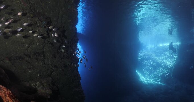 cave diving underwater scuba divers exploring caves and having fun ocean scenery sun beams and rays background