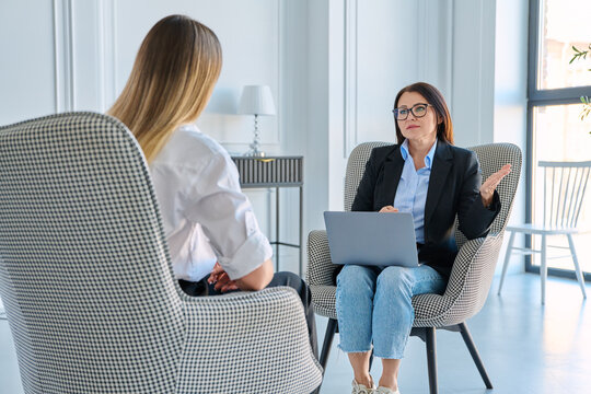 Female recruiter interviewing applicant with laptop in modern office space