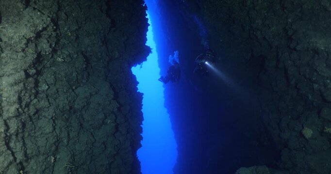 cave diving underwater scuba divers exploring caves and having fun ocean scenery sun beams and rays background