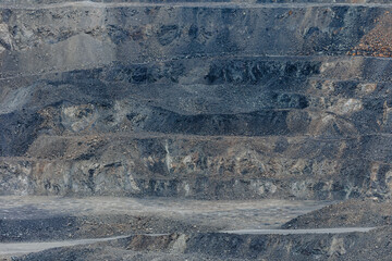 Fototapeta premium Open pit mine showing layered terraces in barren quarry site, gold and copper ore mining