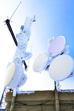 Radio and Satellite Communication Equipment Frozen with snow and Ice in the Winter Dependibility of Communications and Services