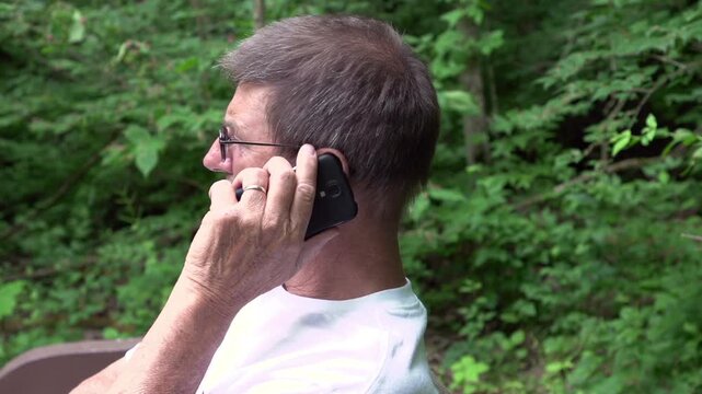Man on bench and telephone in park
