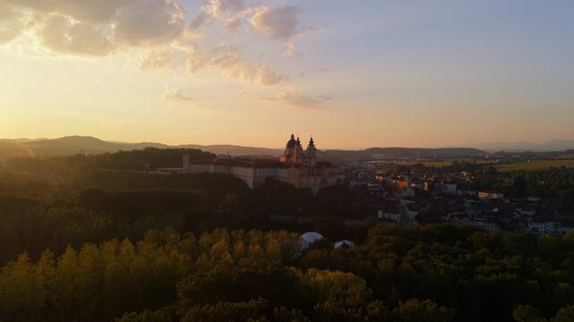 Melk Abbey in Austria, with a beautiful sunrise illuminating the historic Baroque abbey church and its magnificent architecture.