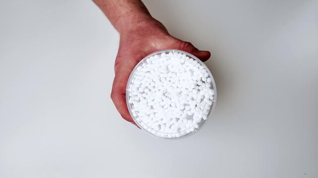Close up view of white salt crystals scattered across a clean white surface, a study in texture and minimalist composition, perfect for culinary or spa themes