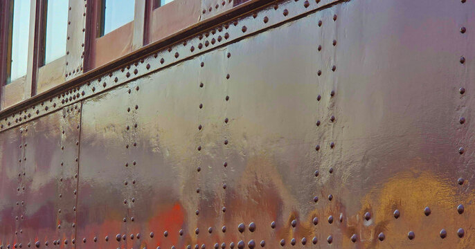 Riveted Steel Side of Train car at train show for Background, Backdrop, Border, Frame, Transportation, antiques, old, vintage, shiny, colorful, rivets, rivet-Colors of Brown, Rust, gold