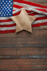 Obraz premium USA flag on burlap with wooden star on rustic wooden background, patriotic composition with copy space for Independence, Flag and Constitution Day design