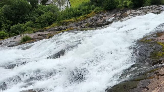Waterfall Hellesyltfossen in Hellesylt village at overcast day, Norway
