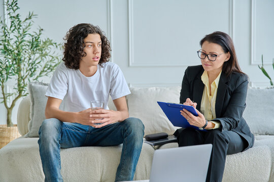 Teen boy talking to female psychologist in office