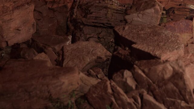 Boulders and stones fill the cave floor in a natural setting. The light creates shadows on the rocky surfaces, showing textures and formations. It is evening.