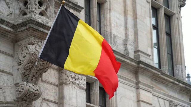 Waving flag of belgium against historic european architecture, national symbol of brussels belgian
