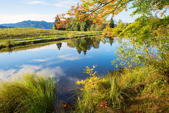 peaceful scenery lake Moorweiher, near Oberstdorf. reflecting clouds and trees in the water